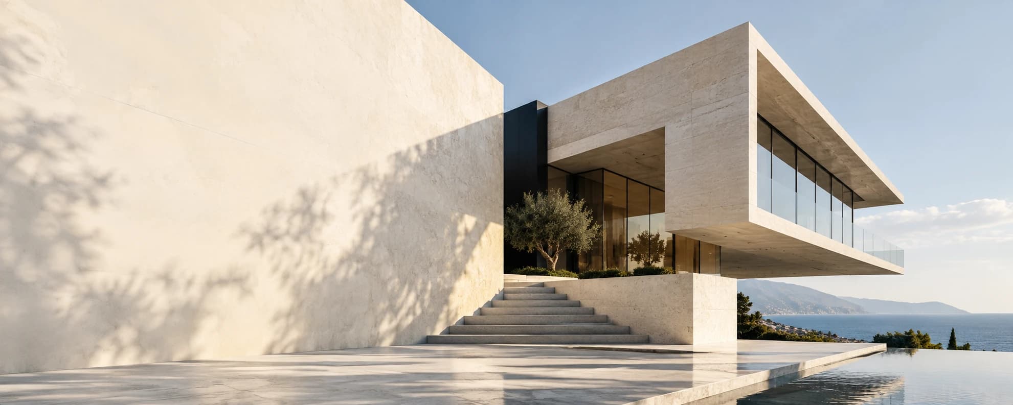 Sunlit limestone coastal home with broad steps, glass walls, and an infinity pool overlooking the sea